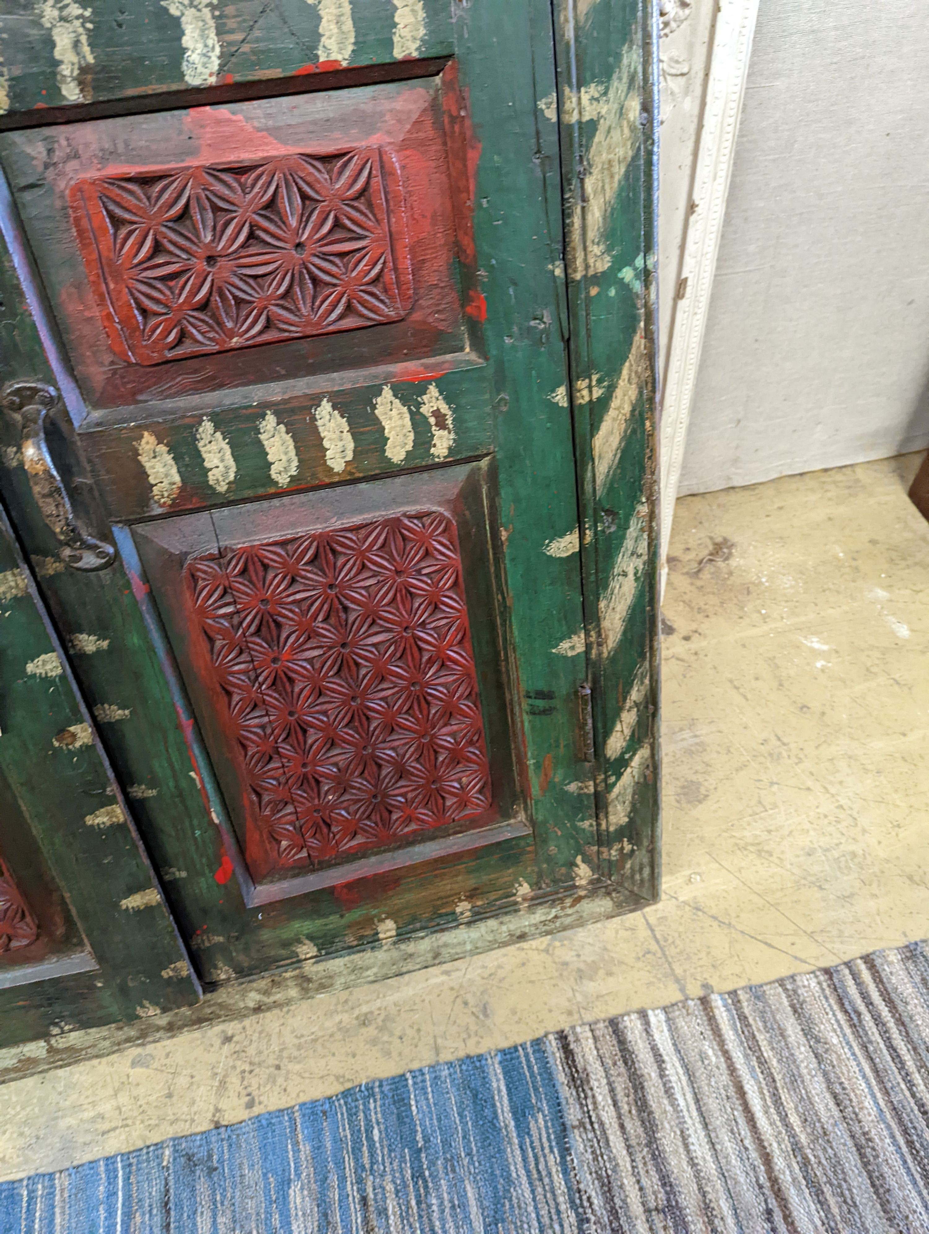 An Indian painted carved hardwood corner cupboard, width 90cm, height 131cm